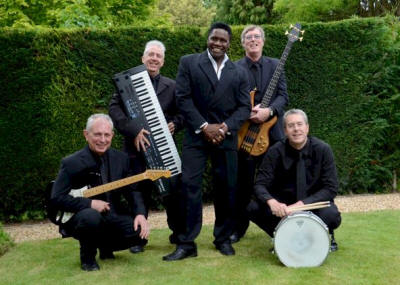 The CT Covers Band Band pose in front of green hedge. They play in Surrey, London and Berkshire